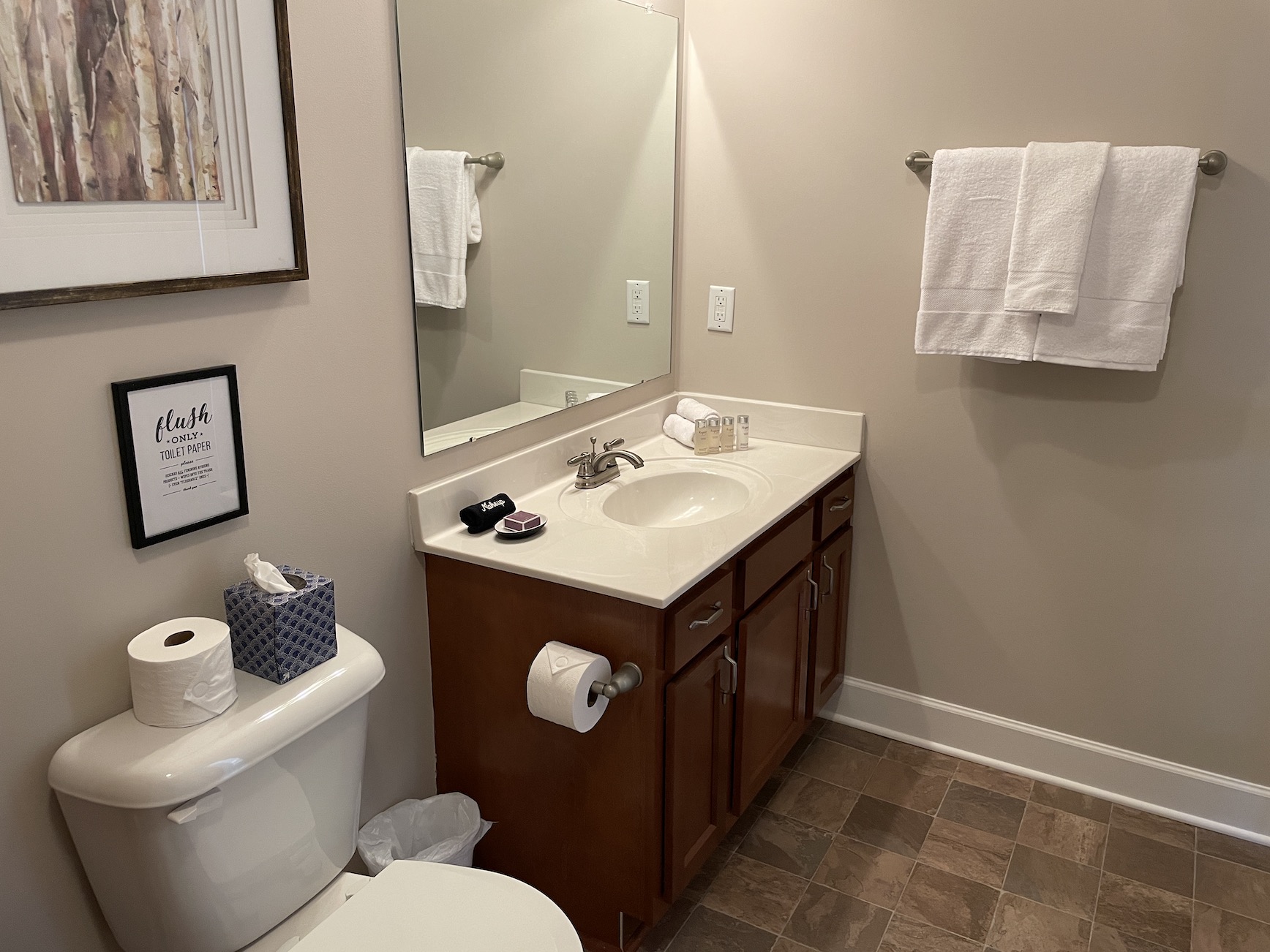 A clean bathroom with a shower tub combo, toilet, and vanity with mirror in a furnished apartment in Westerville Ohio