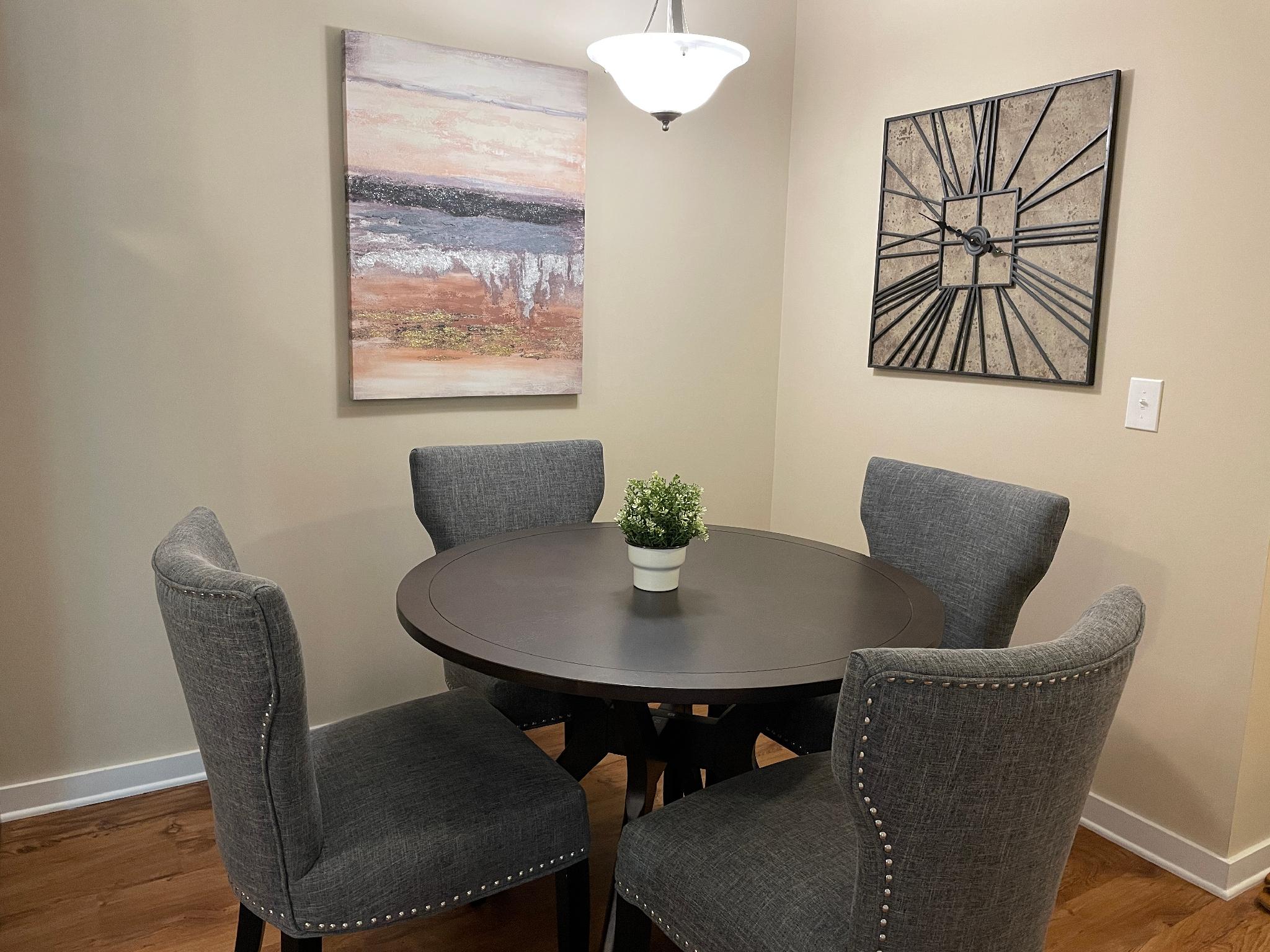 A dining area with a dining table and four chairs in a furnished apartment near New Albany Ohio