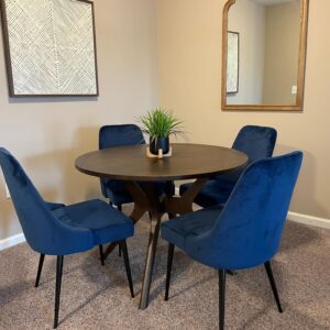 A wooden dining table with blue chairs in a furnished apartment in Hilliard Ohio