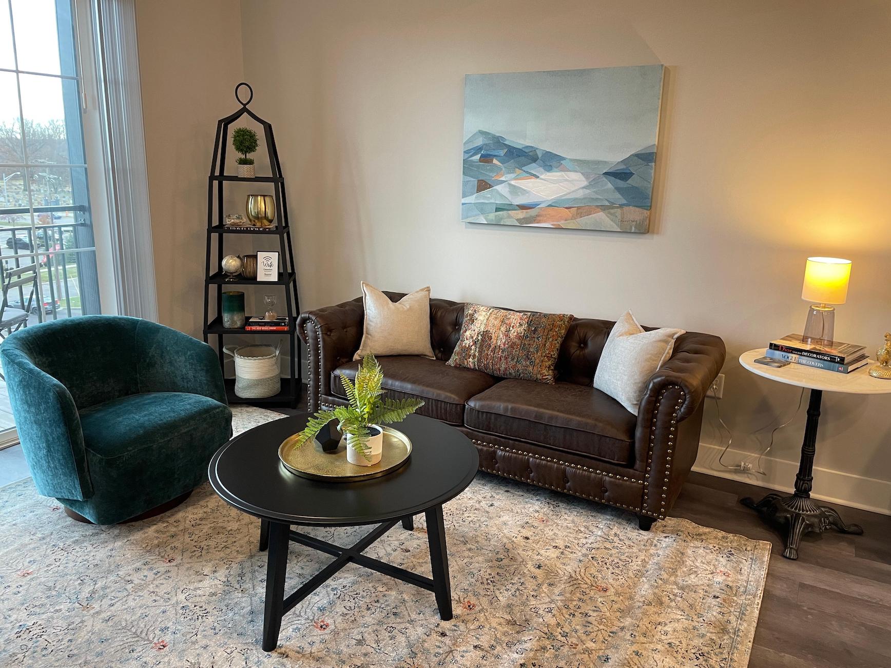 Living room with couch, coffee table, and side chair in a furnished apartment near Ohio State