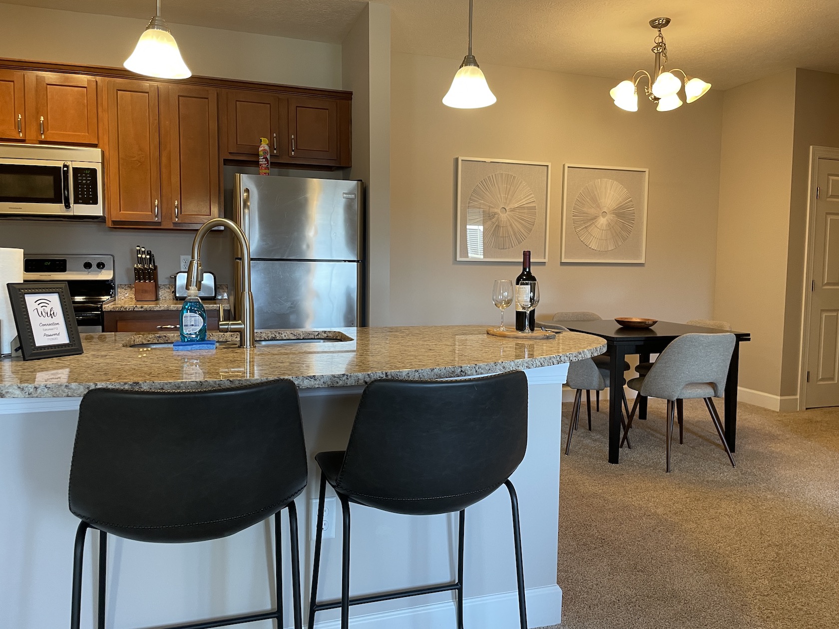 A fully stocked kitchen in a furnished apartment in Westerville Ohio with counter stools and decor