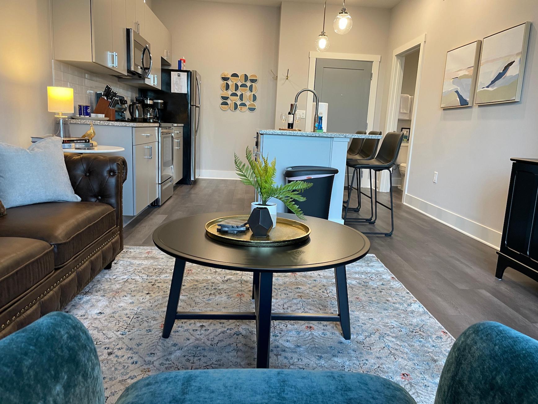 Living room with coffee table and decorative plant in a furnished apartment near Ohio State