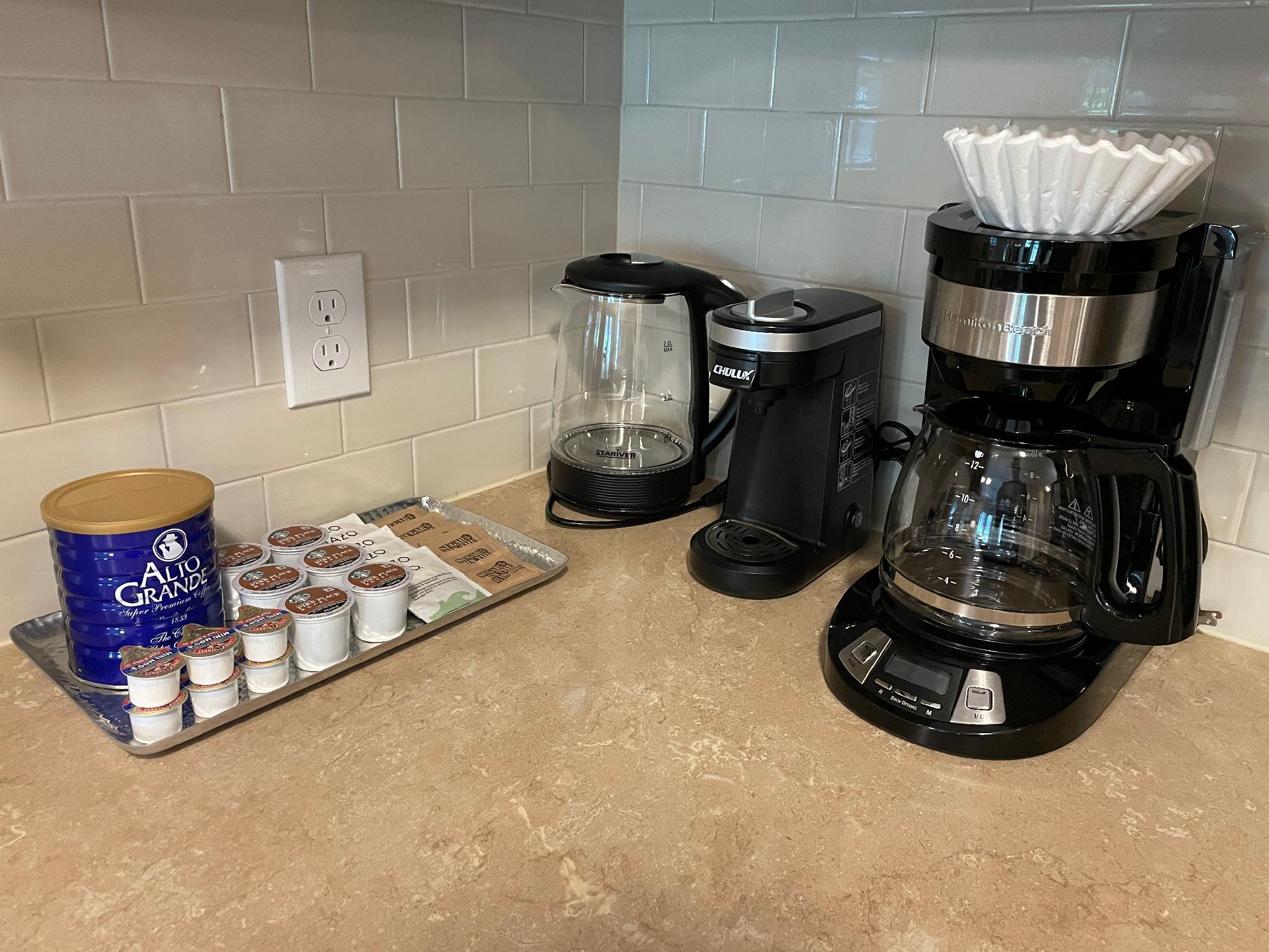 A keurig, drip coffee maker, and coffee and tea supplies on the counter of a furnished apartment near New Albany Ohio