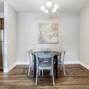 A dining area with a dining table, four chairs, and wall art in a furnished apartment near Westerville Ohio