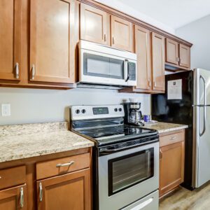 A kitchen with brown cabinets and new appliances in a furnished apartment in Westerville Ohio