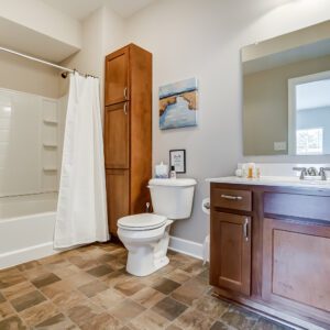 A clean bathroom with a shower tub combo, toilet, and vanity with mirror in a furnished apartment in Westerville Ohio