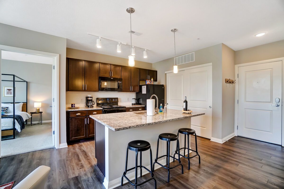 A fully stocked kitchen in a furnished apartment in Downtown Columbus with counter stools