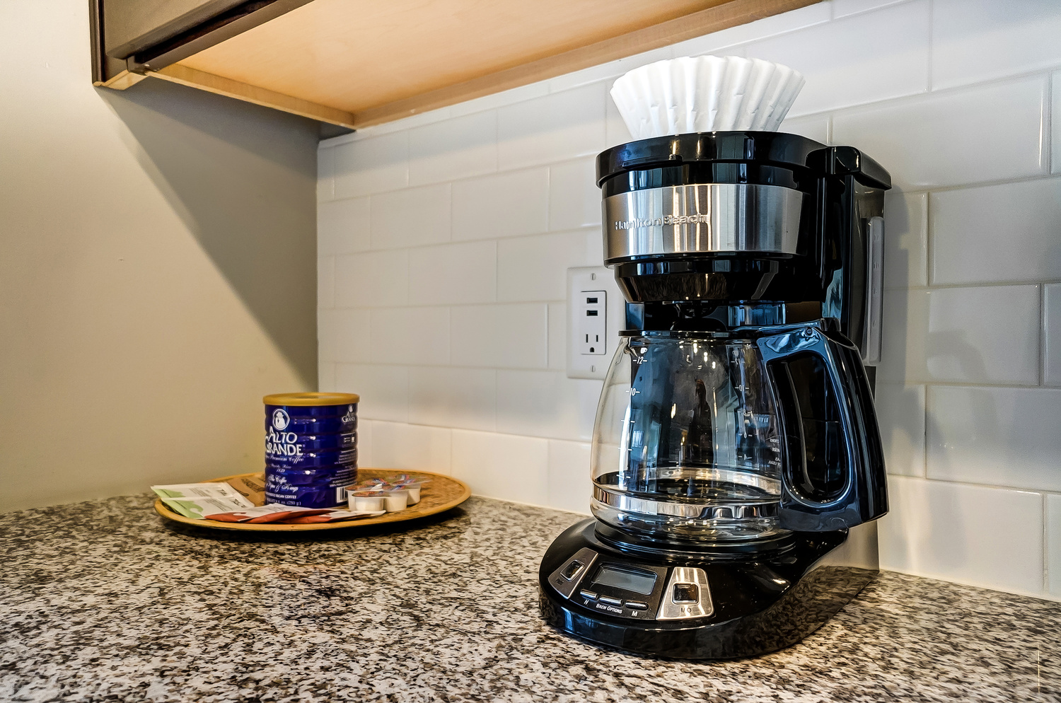 A drip coffee maker, coffee, and tea supplies on the counter of a furnished apartment in downtown Columbus