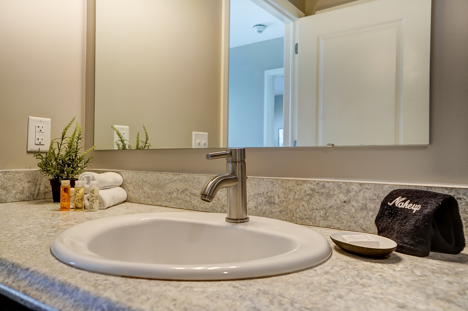 Bathroom vanity with toiletries, rolled wash cloths, and a soap dish in a furnished apartment in Downtown Columbus