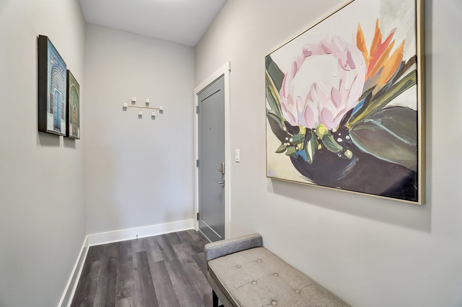 Entry hallway with a large painting of a flower on the wall of a furnished apartment near OSU