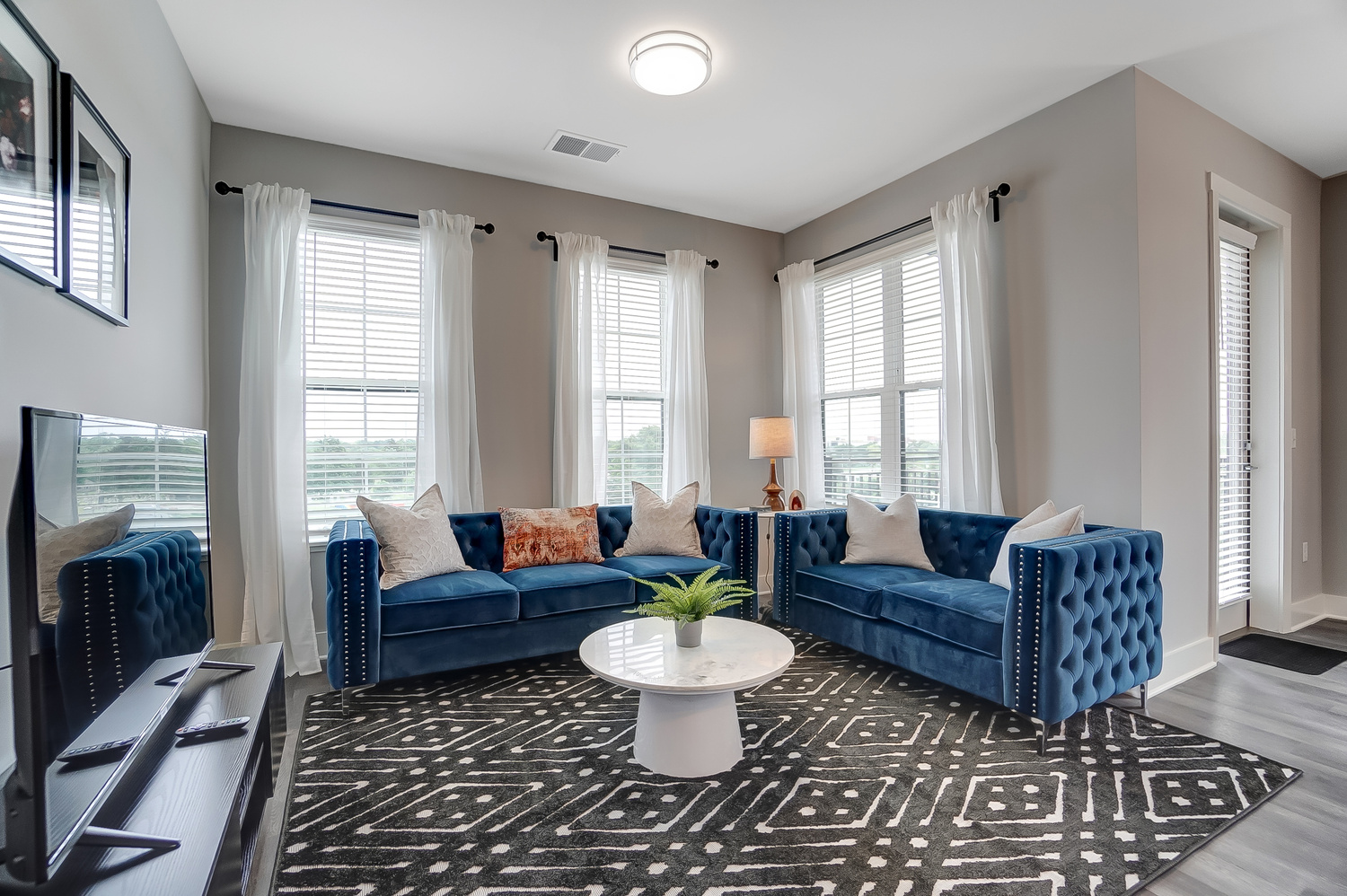 Living room with blue couch, a coffee table, and a side chair in a furnished apartment near OSU