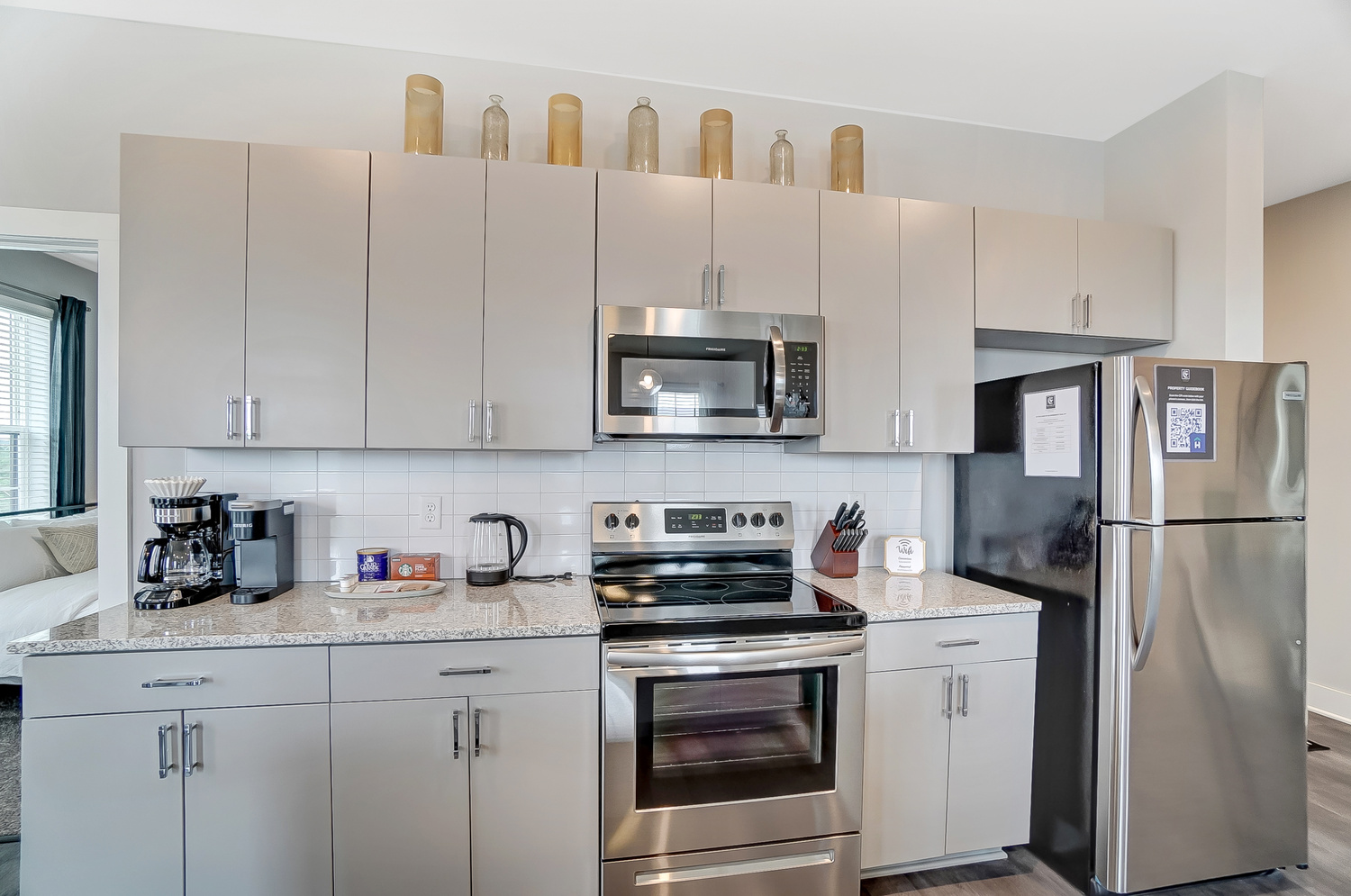 Stylish kitchen in a furnished apartment near OSU stocked with a tea kettle, coffee maker stainless steel appliances, and more.