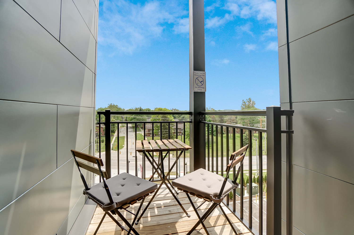 The balcony of a furnished apartment near OSU with chairs and a table.