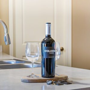 A bottle of wine and two clean wine glasses on the kitchen counter of a furnished apartment in Hilliard Ohio