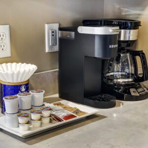 A drip coffee maker, Keurig, coffee, and tea supplies on the counter of a furnished apartment in Hilliard Ohio