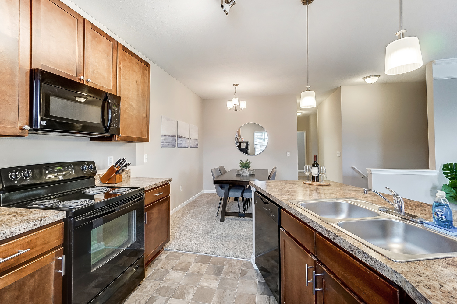 A view of a kitchen and a dining area in a furnished apartment near New Albany Ohio