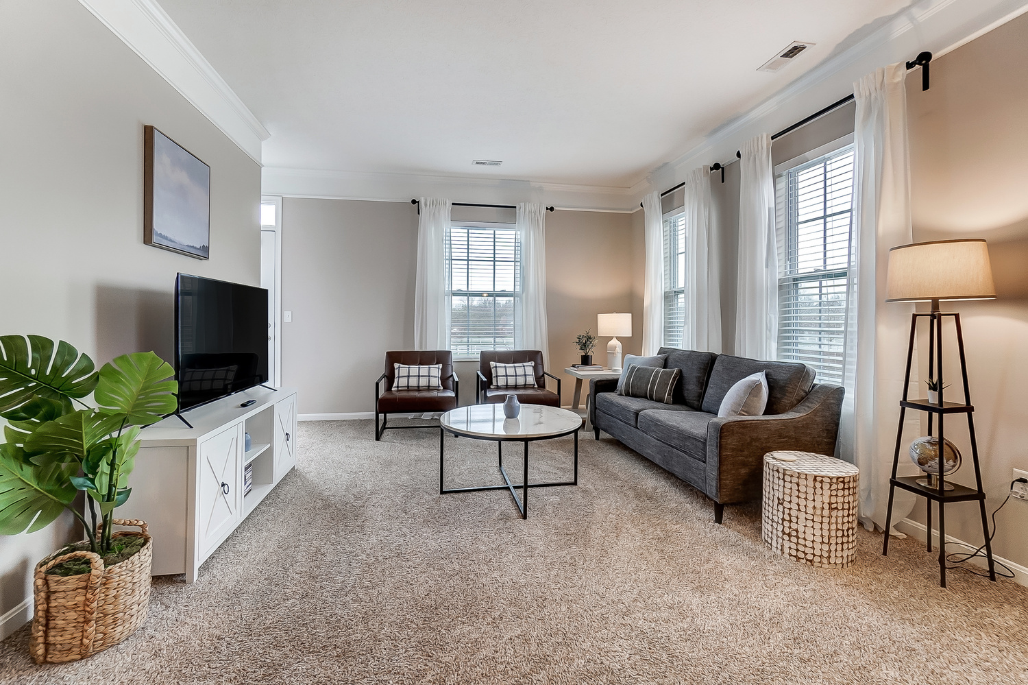 A living room with a couch, chairs, and a coffee table in a furnished apartment near New Albany Ohio