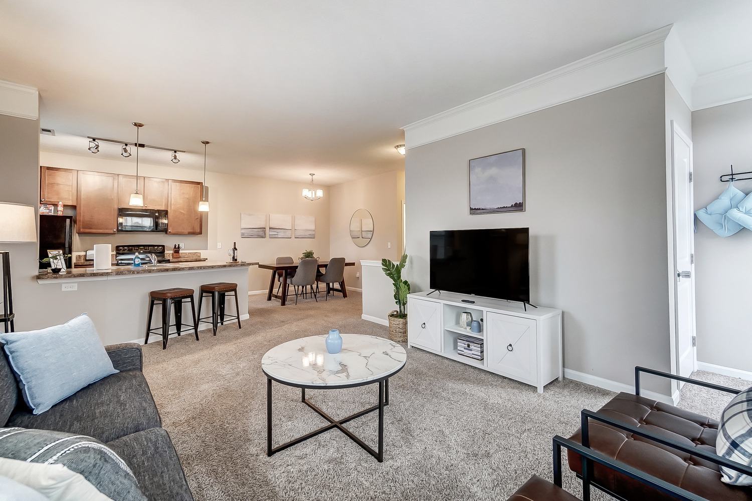 A living room with a smart TV in a furnished apartment near New Albany