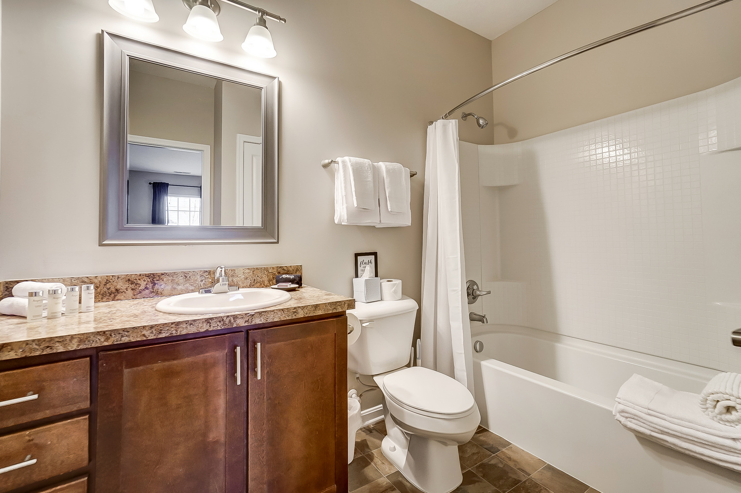 A bathroom vanity, a toilet, and a bathtub in a furnished apartment near New Albany Ohio