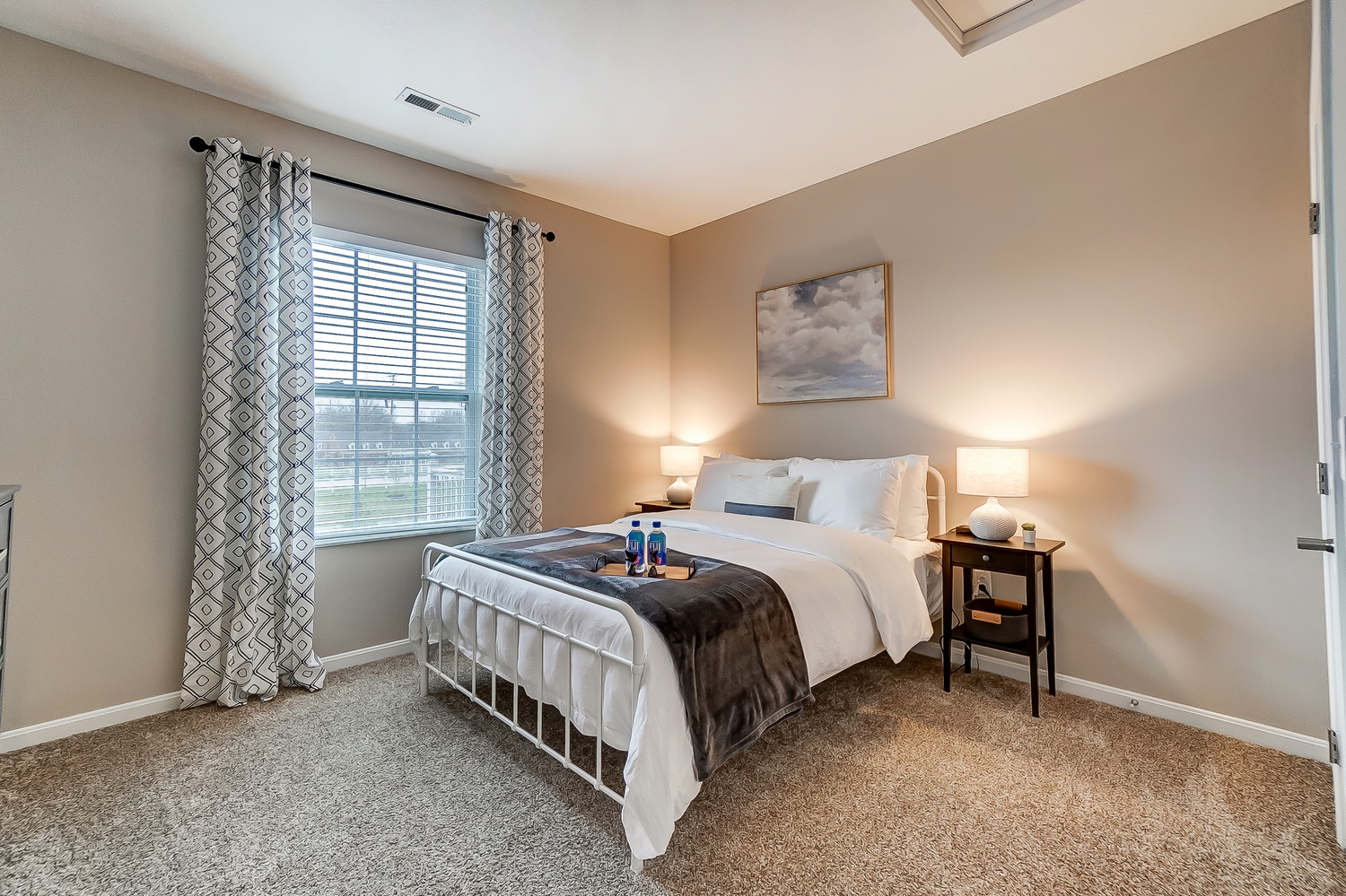 A queen bed in the bedroom of a furnished apartment near New Albany Ohio