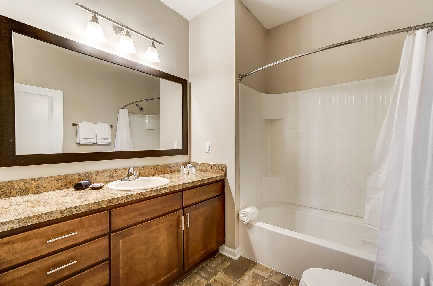 A bathroom vanity, a toilet, and a bathtub in a furnished apartment near New Albany Ohio