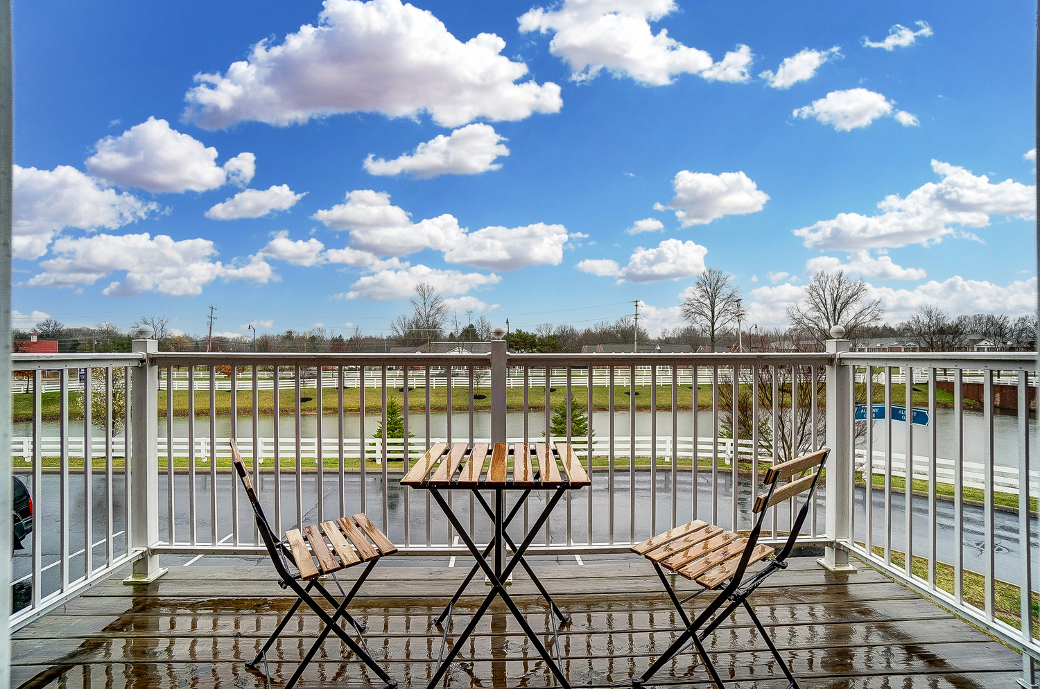 The balcony of a furnished apartment near New Albany Ohio with a view of water and a blue sky