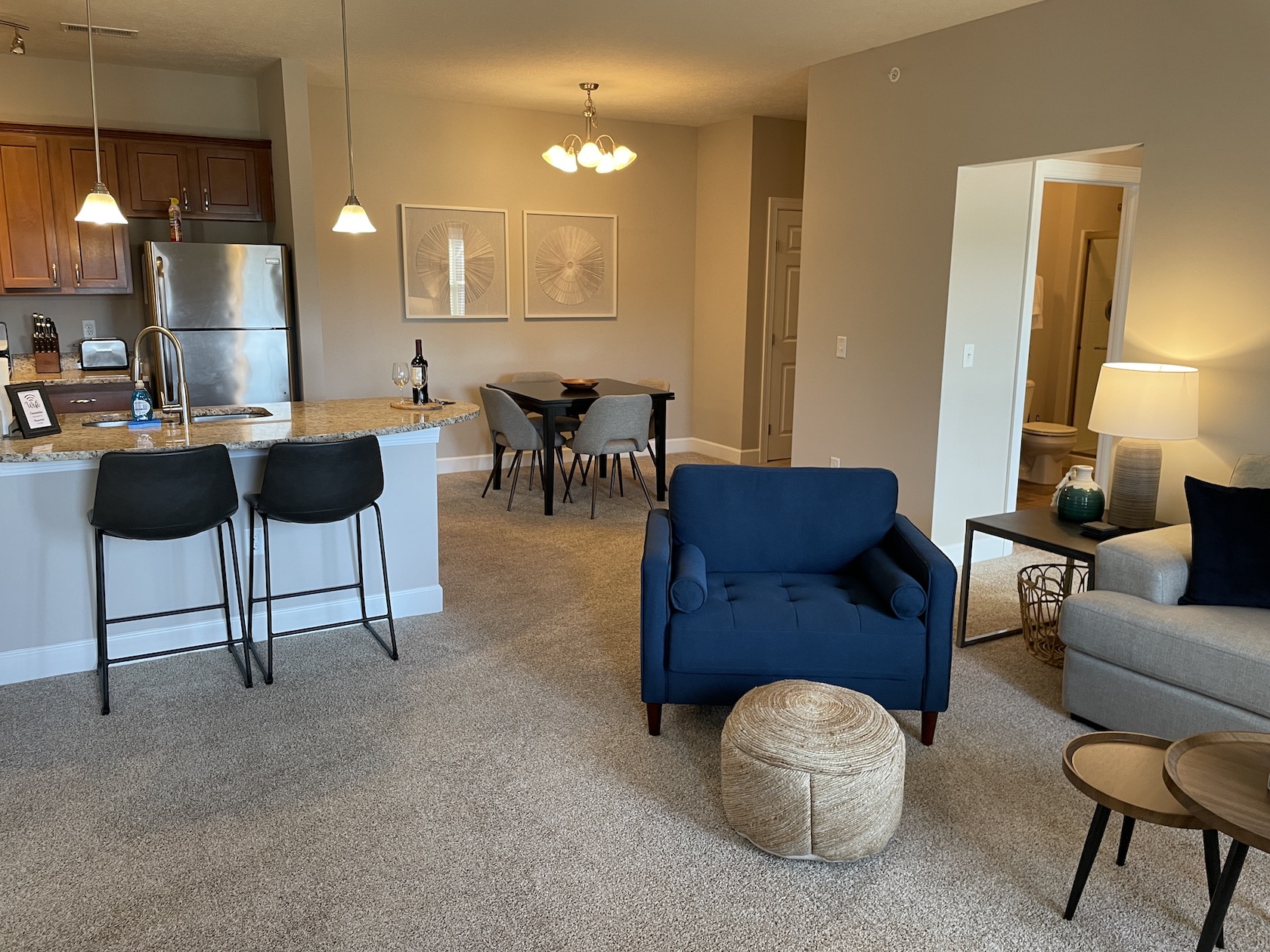 An open concept living space with a living room, dining area, and kitchen in a furnished apartment in Westerville Ohio