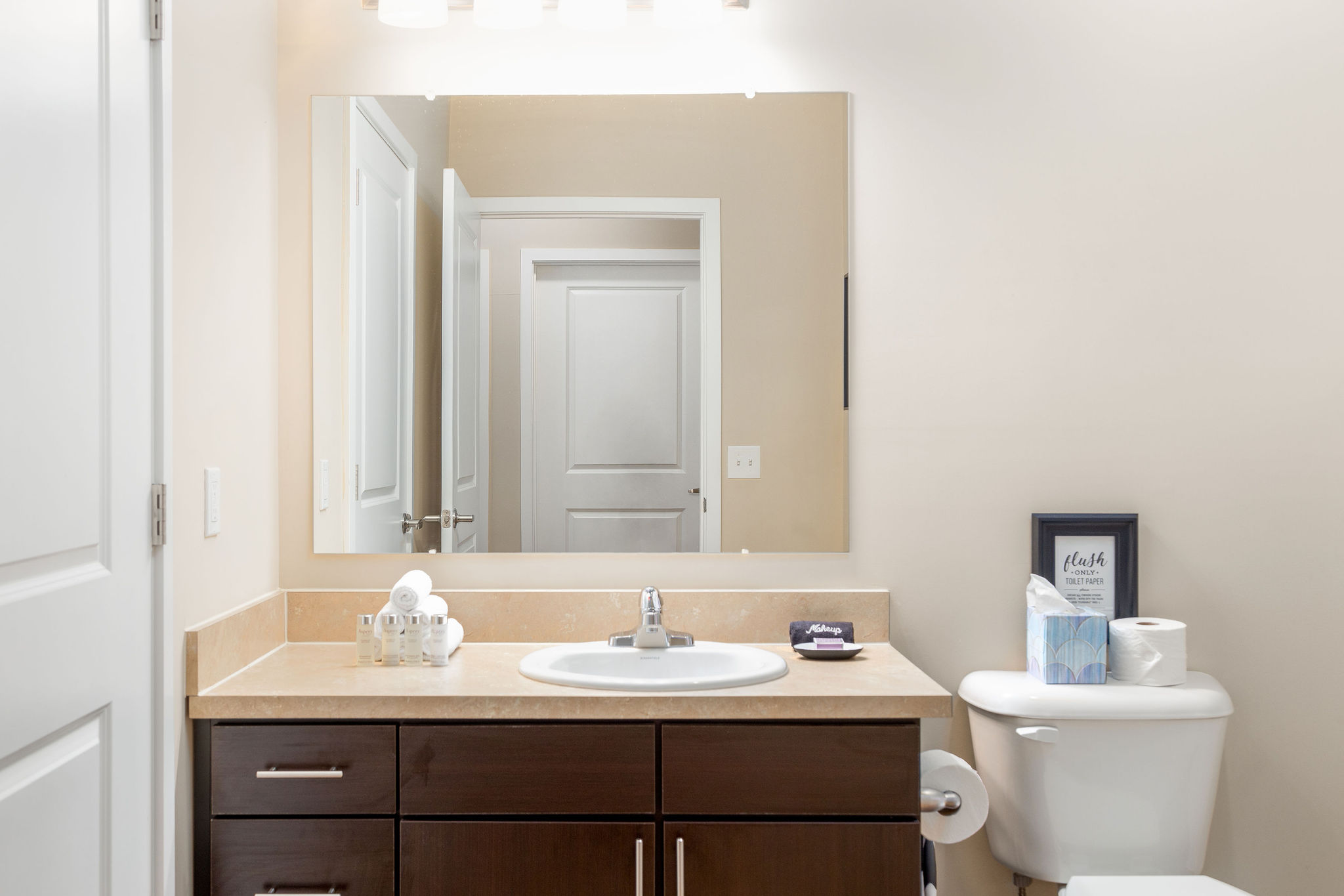 A bathroom vanity with a mirror in a furnished apartment near New Albany Ohio