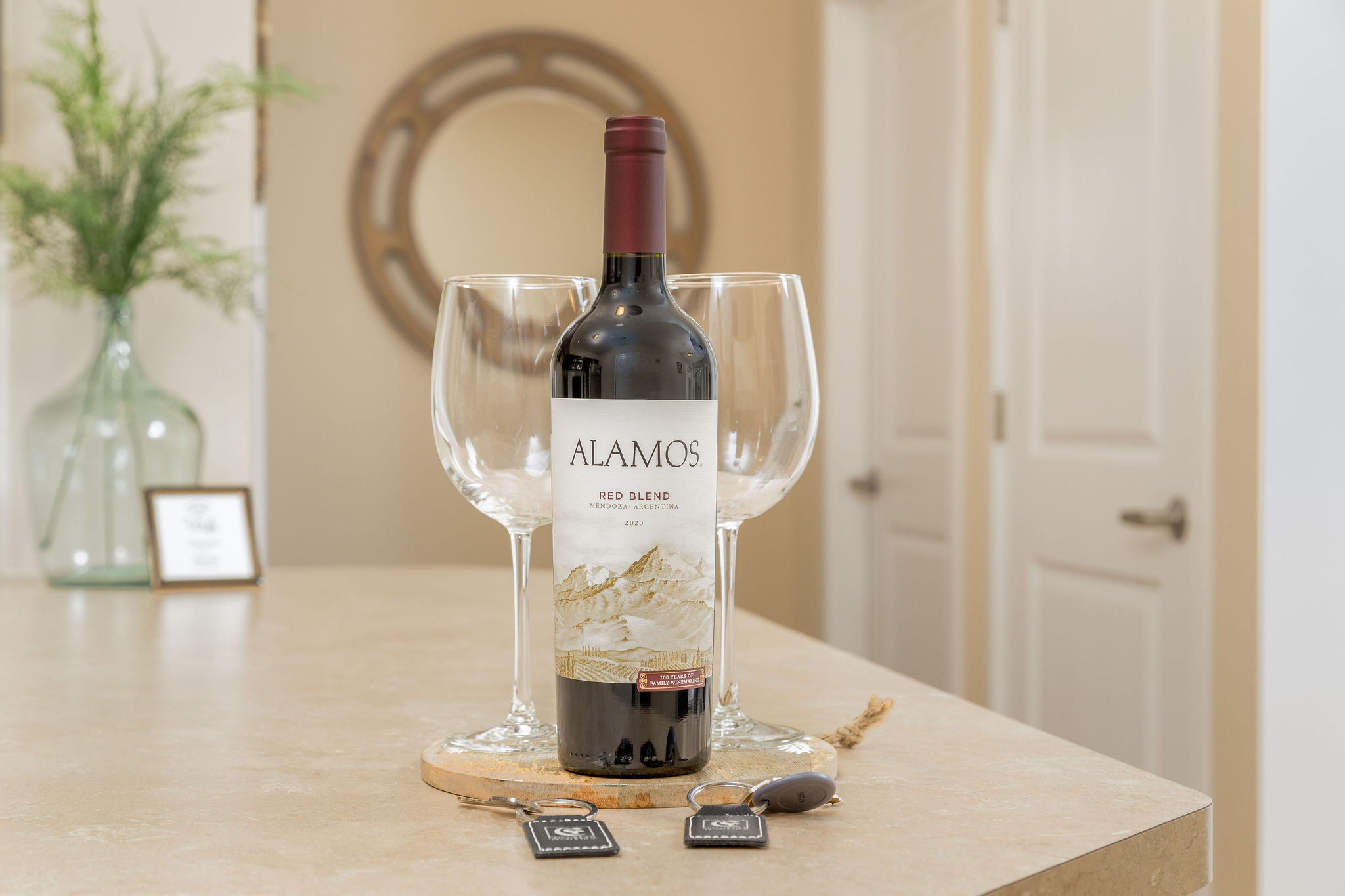 A bottle of wine and two clean wine glasses on the kitchen counter of a furnished apartment near New Albany Ohio