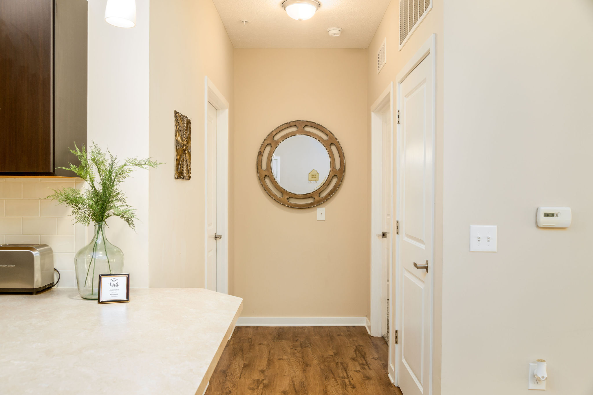 A hallway with a mirror at the end in a furnished apartment near New Albany Ohio