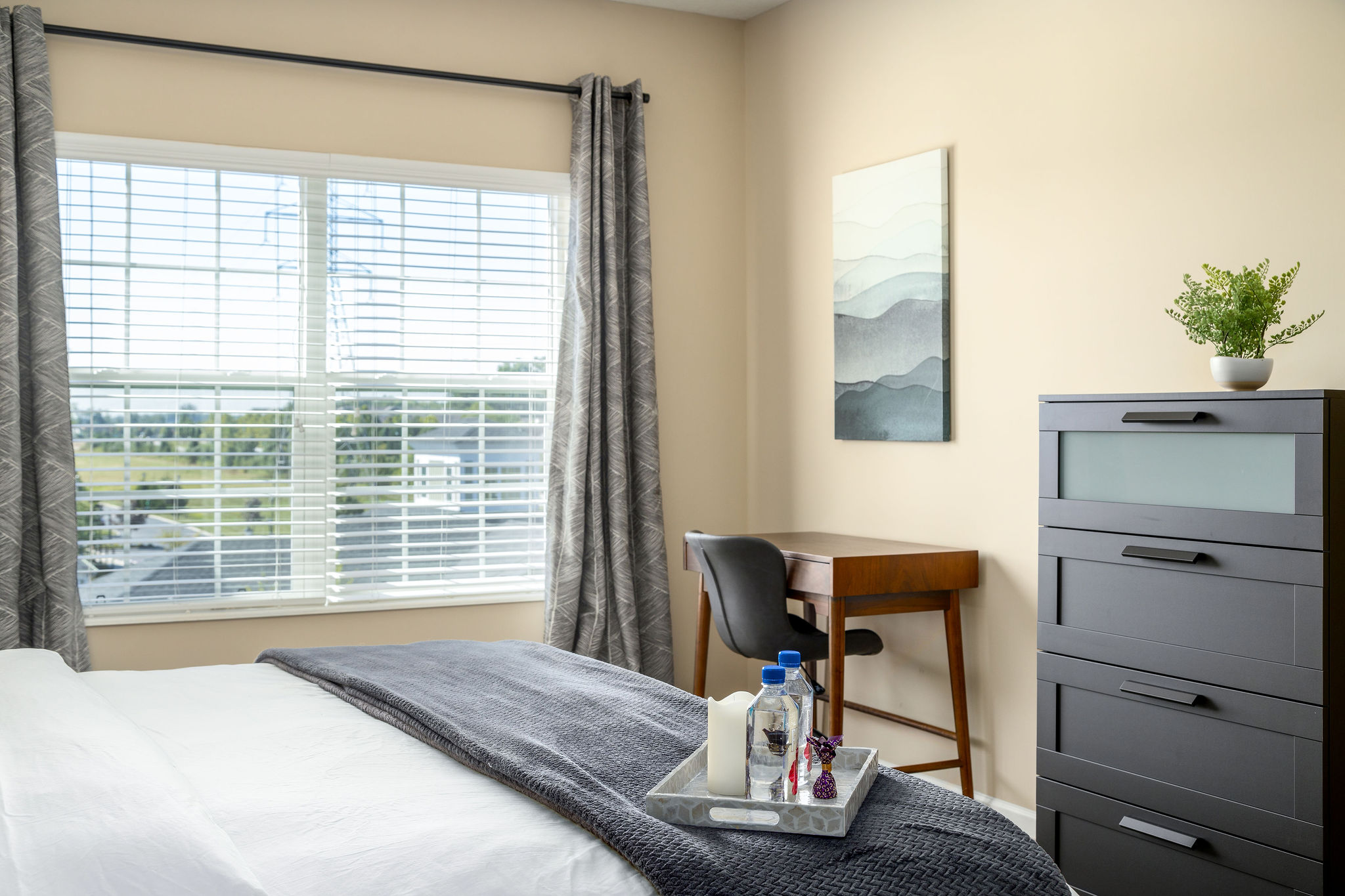 King bed, a dresser, and a desk in the bedroom of a furnished apartment near New Albany Ohio