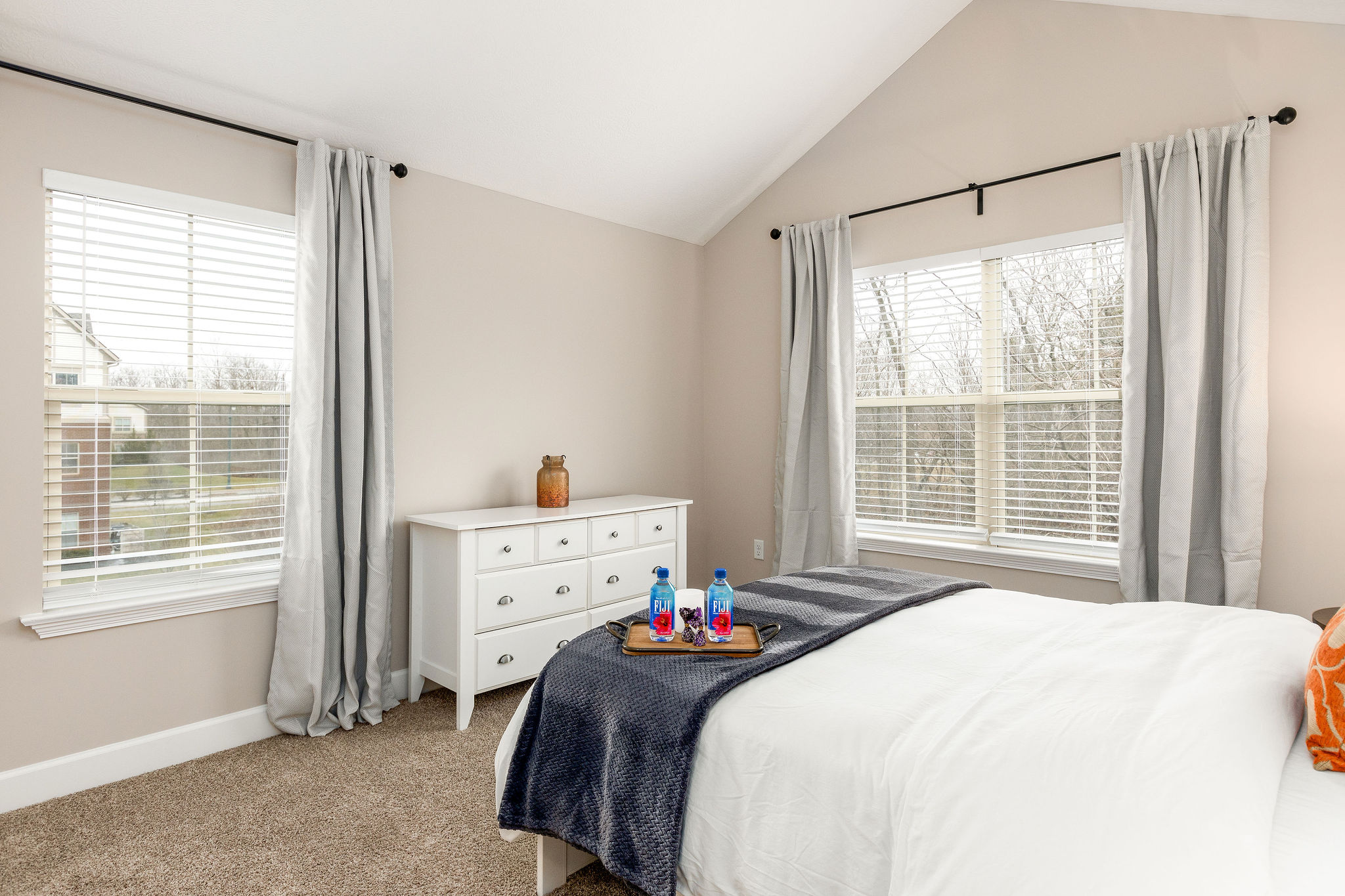 Bedroom with dresser, wall art, and large windows in a furnished apartment in Westerville Ohio