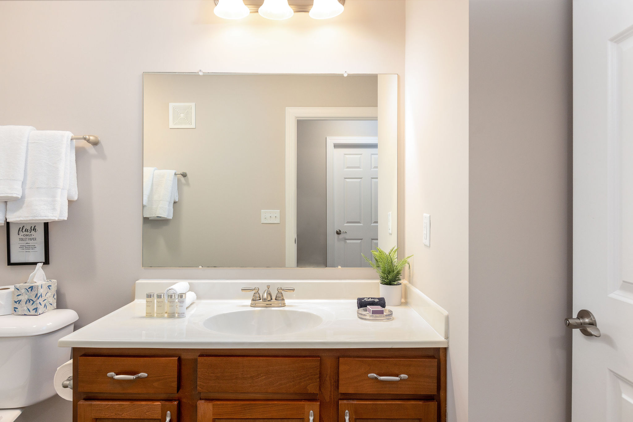 A bathroom vanity with a mirror in a furnished apartment in Westerville Ohio