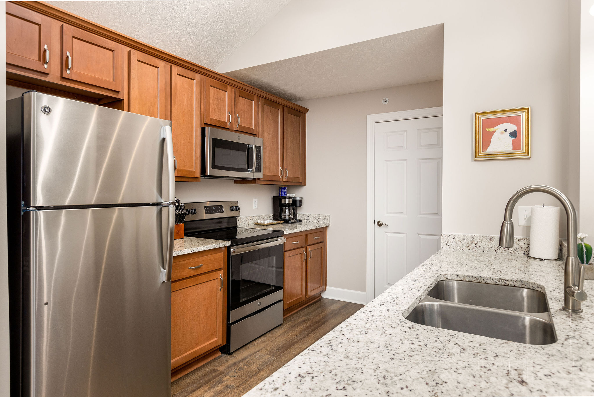 A kitchen with brown cabinets and new appliances in a furnished apartment in Westerville Ohio