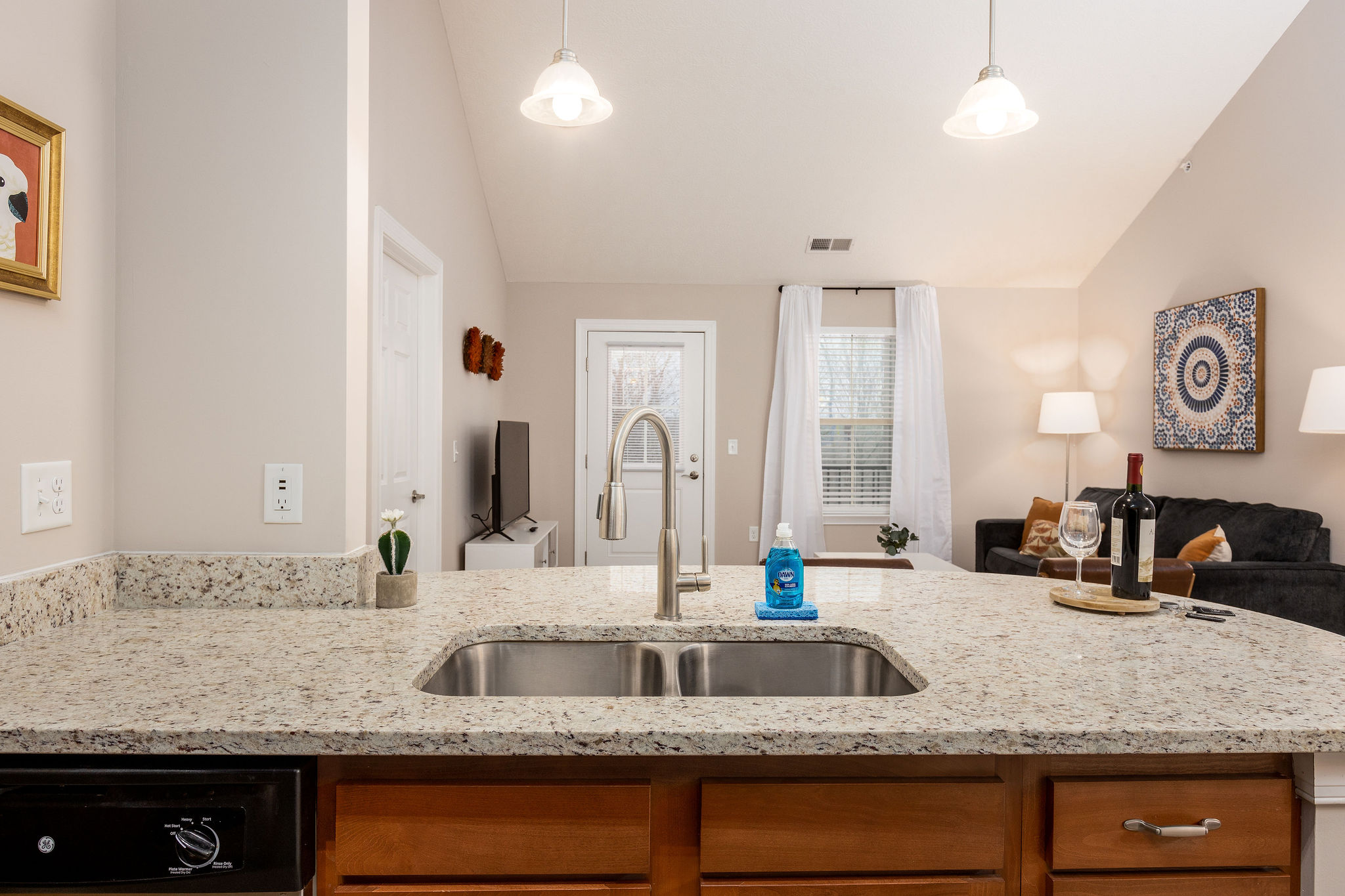 A kitchen counter with a sink and stainless steel dishwasher in a furnished apartment in Westerville Ohio