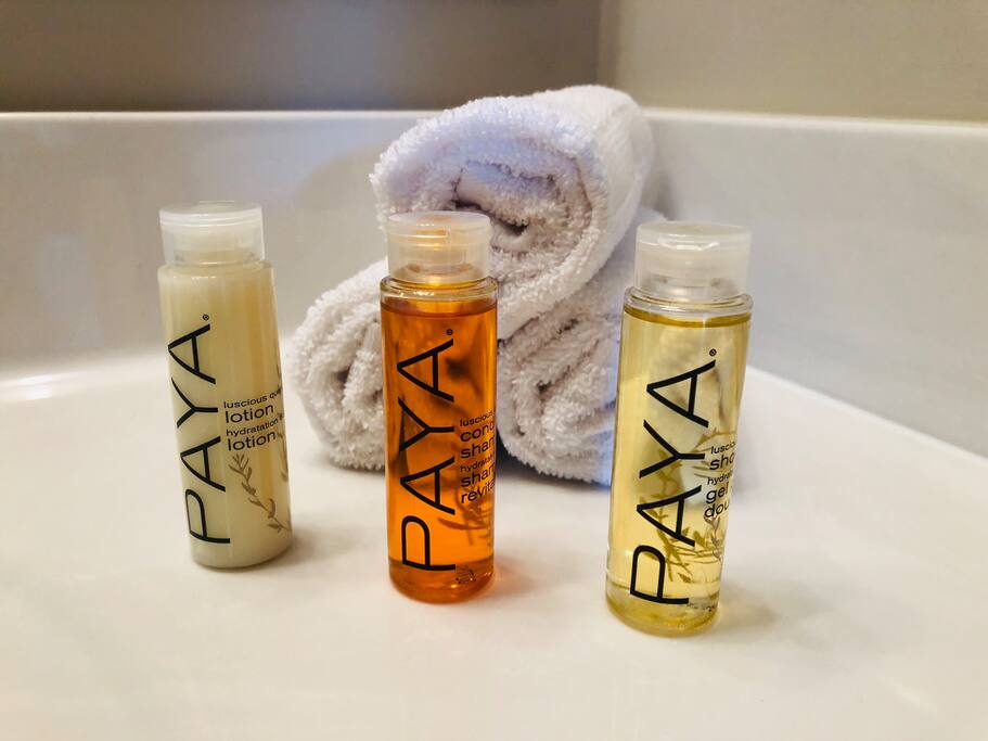 Toiletry bottles lined up in front of rolled wash clothes on the bathroom vanity of a furnished apartment in downtown Columbus