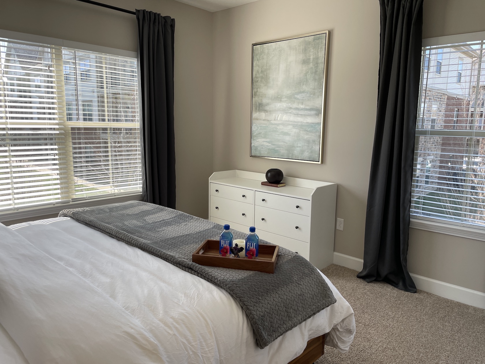 Bedroom with king bed, wall art, and dresser in a furnished apartment in Westerville Ohio