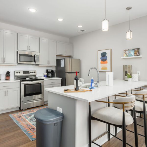 A kitchen in a furnished apartment in downtown Columbus Ohio with counter stools, art, and decor