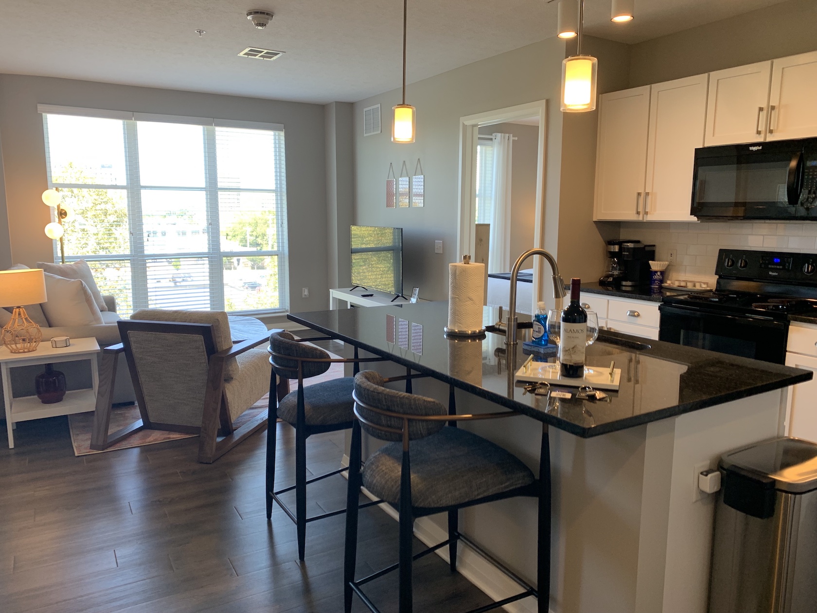 An open concept living space with a living room, dining area, and kitchen in a furnished apartment in Downtown Columbus