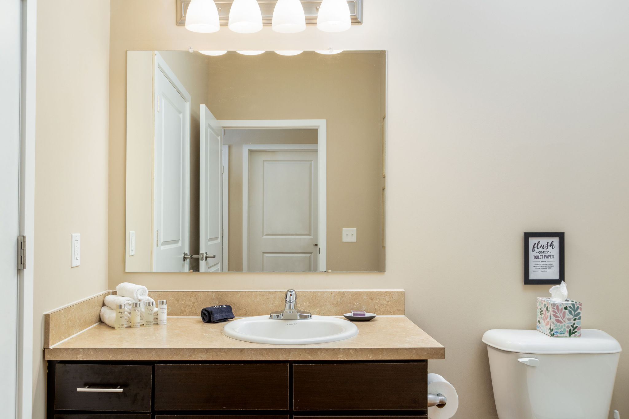 A bathroom vanity with a mirror in a furnished apartment near New Albany Ohio