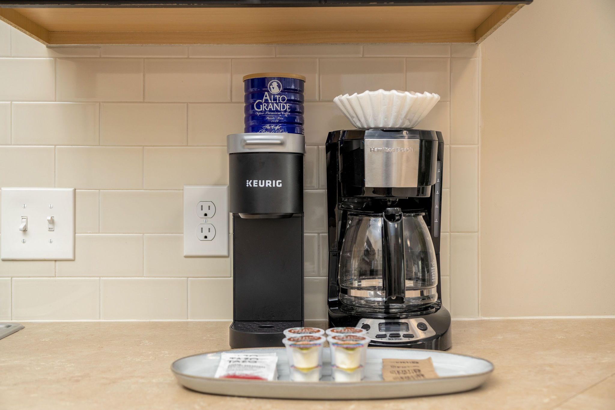 A keurig, drip coffee maker, and coffee and tea supplies on the counter of a furnished apartment near New Albany Ohio