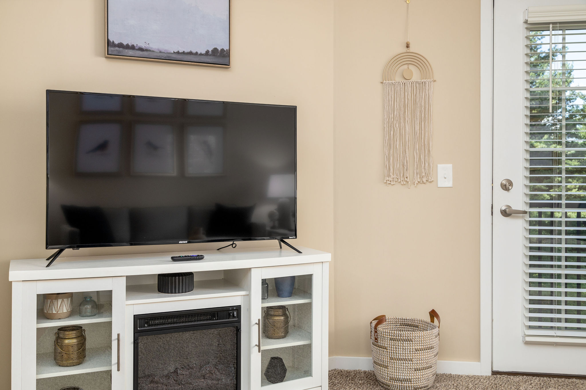 A smart TV on a TV stand in the living room of a furnished apartment near New Albany Ohio