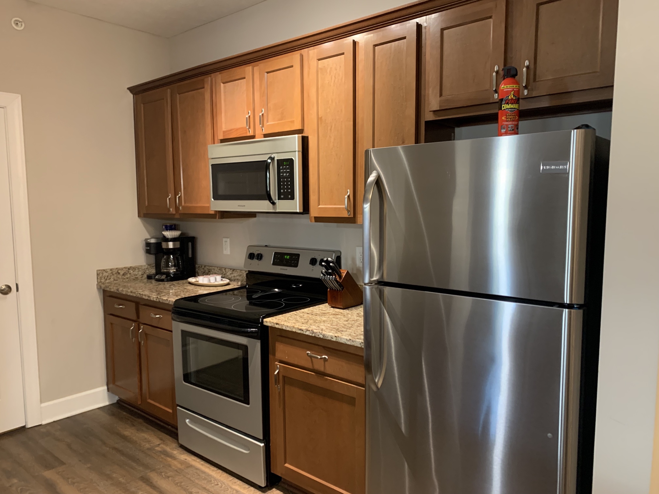 A kitchen with brown cabinets and new appliances in a furnished apartment in Westerville Ohio