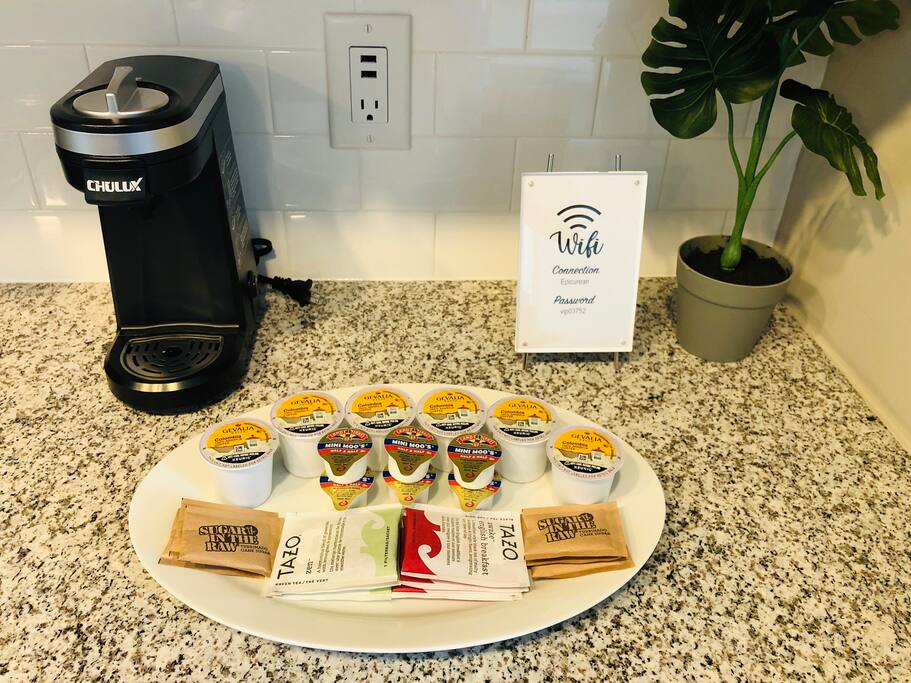 A tray with tea bags, k-cups, creamer, and sugar packets in a furnished apartment in downtown Columbus