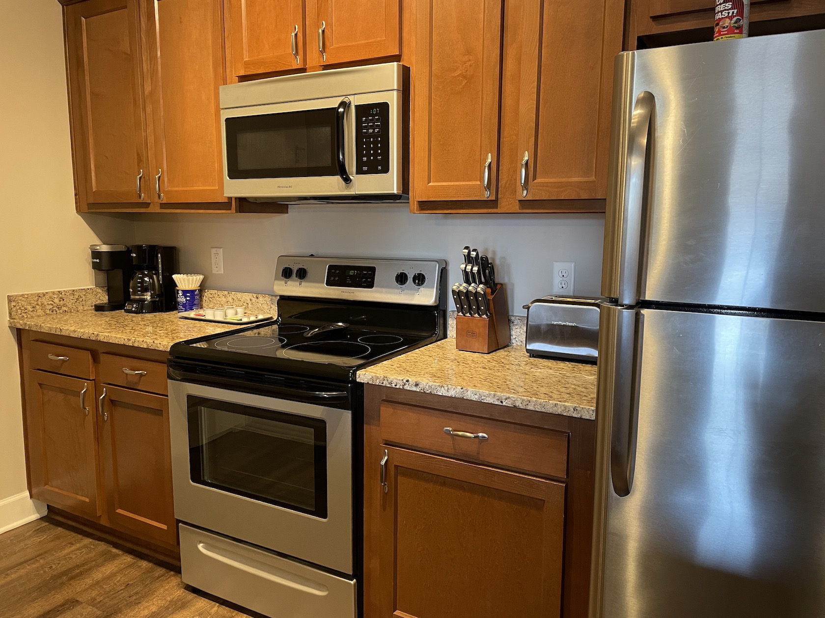 A kitchen with brown cabinets and new appliances in a furnished apartment in Westerville Ohio