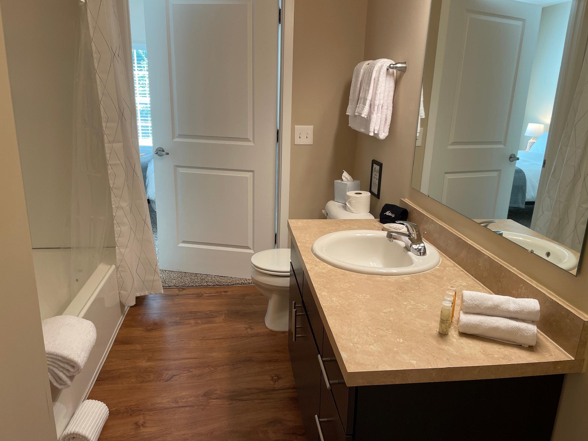 Clean bathroom with white towels attached to a bedroom in a furnished apartment near New Albany Ohio