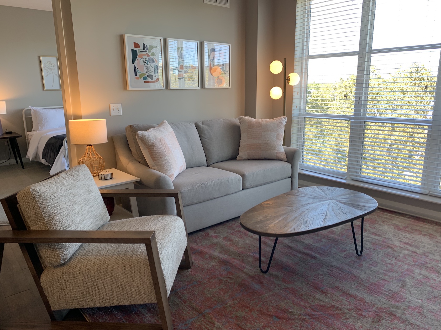 Living room with couch, coffee table, side chair, and large windows in a furnished apartment in Downtown Columbus