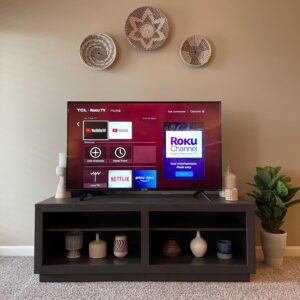 A smart TV and tv stand with designer decor in a furnished apartment in Hilliard Ohio