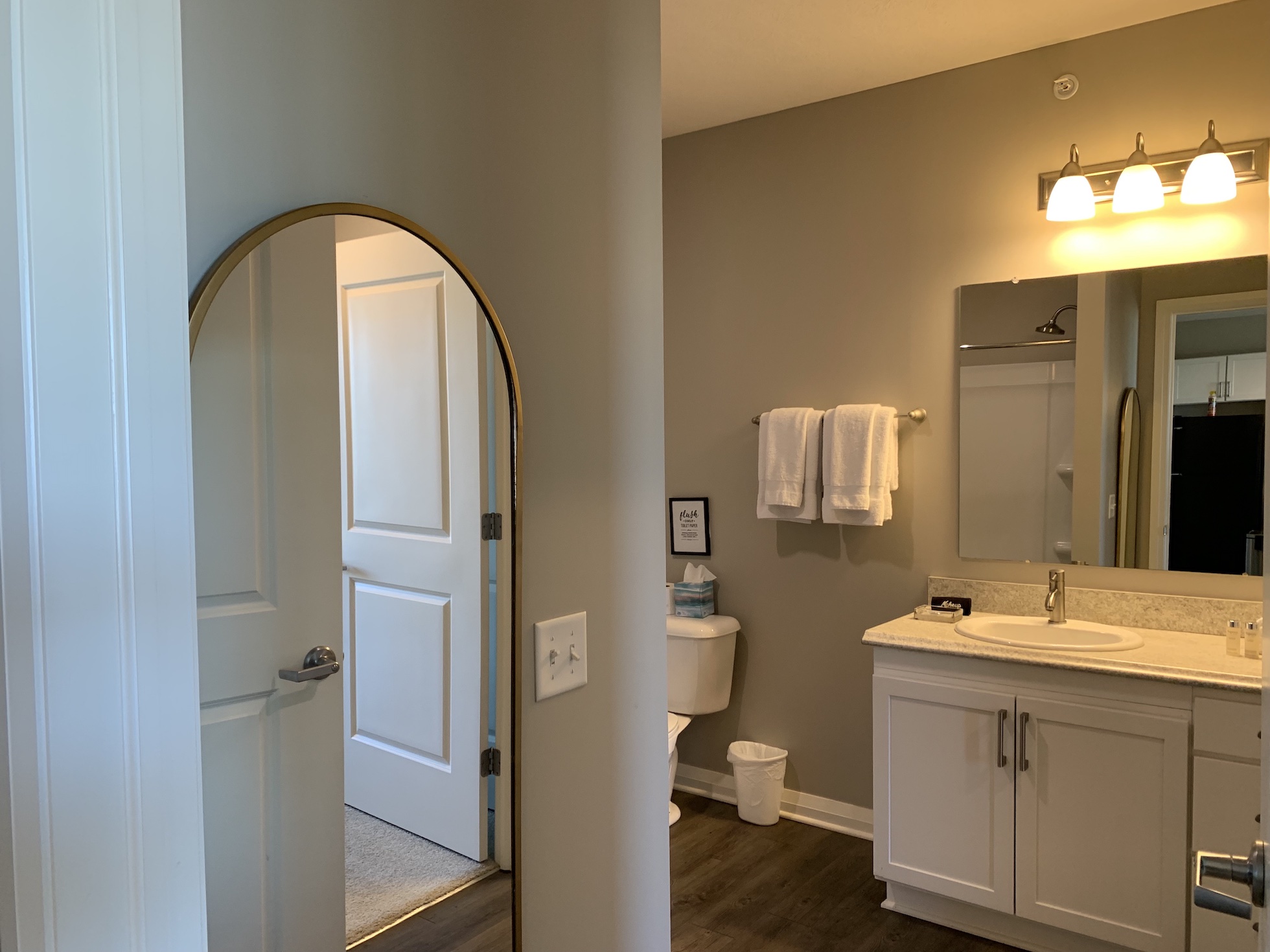 A bathroom with a full length mirror in the entry in a furnished apartment in Downtown Columbus