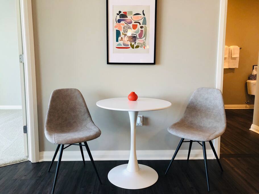 Dining table and chairs next to a wall with art in a furnished apartment in Downtown Columbus